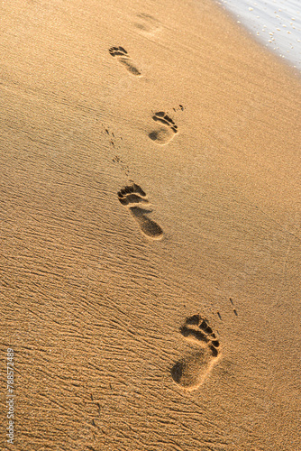 beach, sand and footsteps at sunset time.