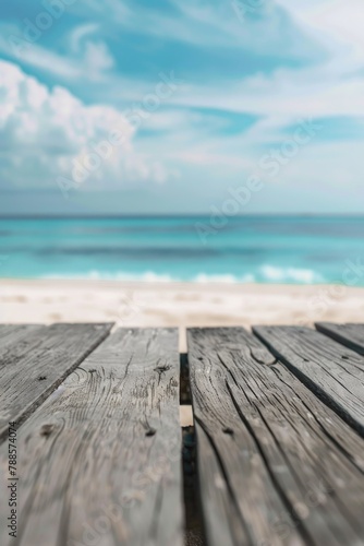 A wooden table on a beach with the ocean in the background. Suitable for travel and vacation concepts