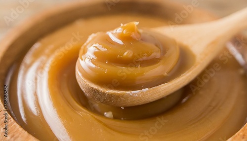 Top view of dulce de leche in wooden spoon. Macro. 