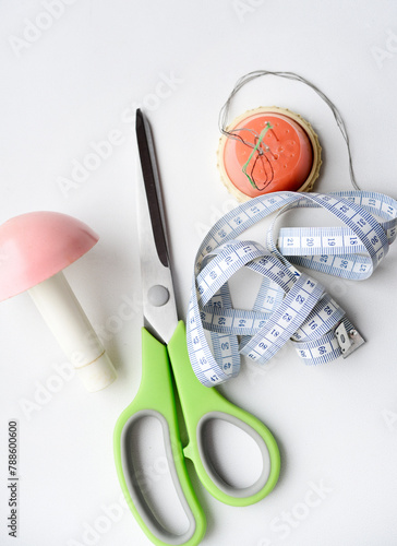 Sewing scissors, measuring tape and thread with a needle. Sewing kit.