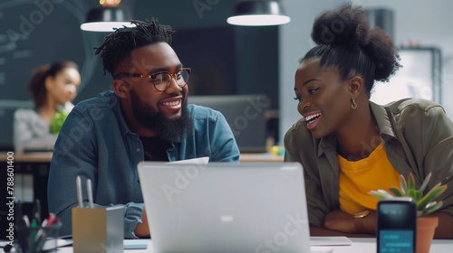 young handsome black man and young beautiful black woman working at the office front of the laptop computer photo