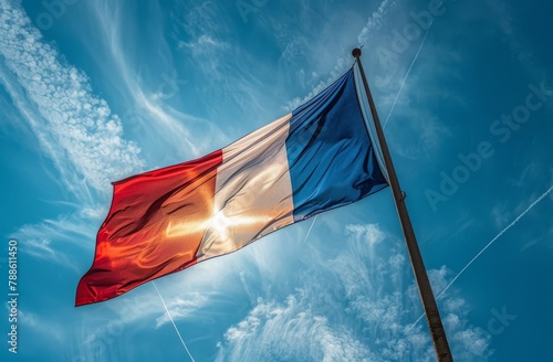 A red, white, and blue French flag is flying in the sky