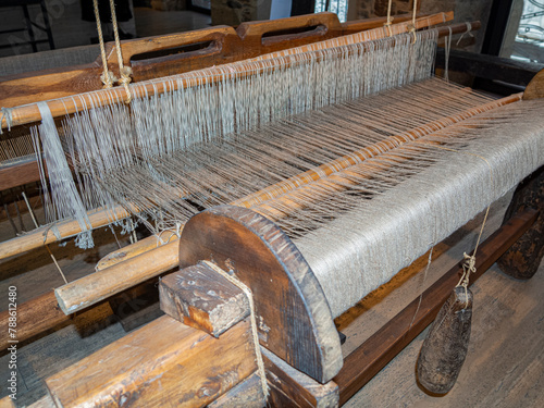 Vista de los hilos de color hueso de un entramado de tejido en un telar antiguo de madera, España, verano de 2021 en Galicia