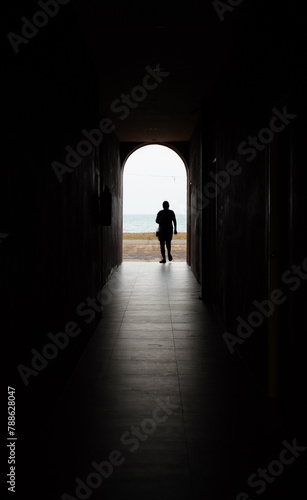 silhouette of a person walking in a tunnel