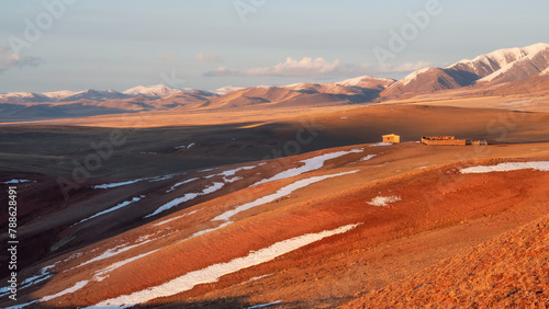 Bright sunny steppe landscape with a wooden barn