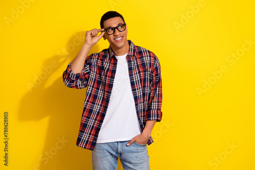 Portrait of nice young man touch glasses look empty space wear shirt isolated on yellow color background