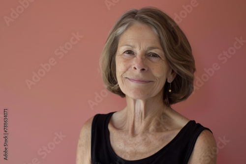 An older woman wearing a black tank top smiles for the camera