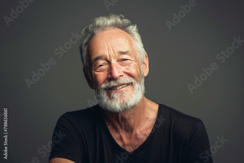 A man with a beard is smiling and wearing a black shirt