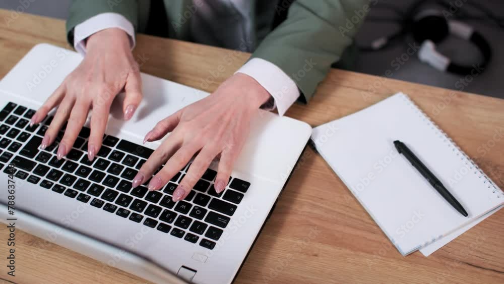 young woman working at a computer typing text on keyboard while sitting at a table in room, close-up young woman working at a computer typing text on keyboard while sitting at a table in room, close-up