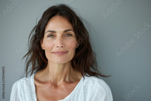 A woman in a white shirt is smiling for the camera