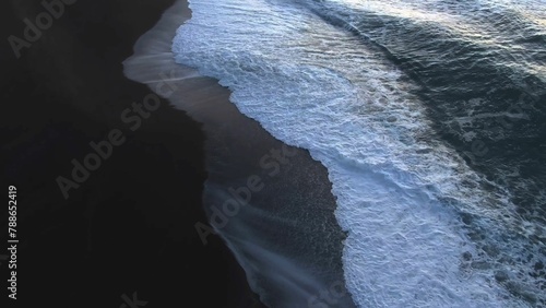 Aerial view of waves crashing on a black sand beach, Dramatic seascape with black sand beach and crashing waves, Black volcanic sand beach with white ocean foam, Panoramic view of a rugged coastline w