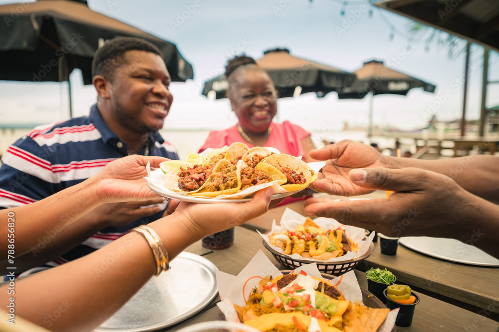 A group of African American friends shared tacos at a beach restaurant. Garifuna group from Guatemala. A group of African American friends shared tacos at a beach restaurant. Garifuna group from Guatemala.