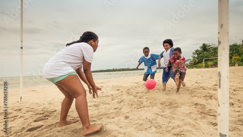Girl waiting for the ball to reach the goal area to catch it, in a soccer game on the beach. photo