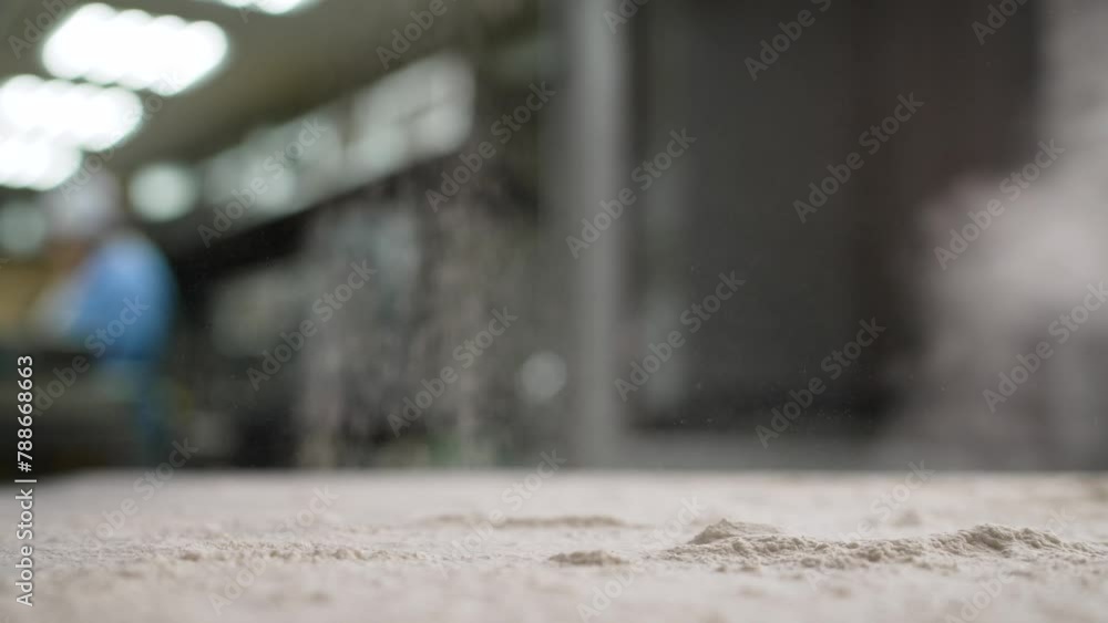 Flour pours onto the table, slow motion. Very slowly pour the flour onto the baking table. Kitchen in a restaurant, baking from flour. A chef sprinkles white wheat flour on a black table before prepar Flour pours onto the table, slow motion. Very slowly pour the flour onto the baking table. Kitchen in a restaurant, baking from flour. A chef sprinkles white wheat flour on a black table before prepar