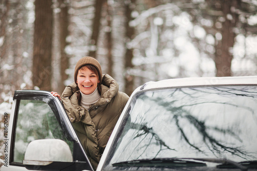 Happy woman driving car in winter