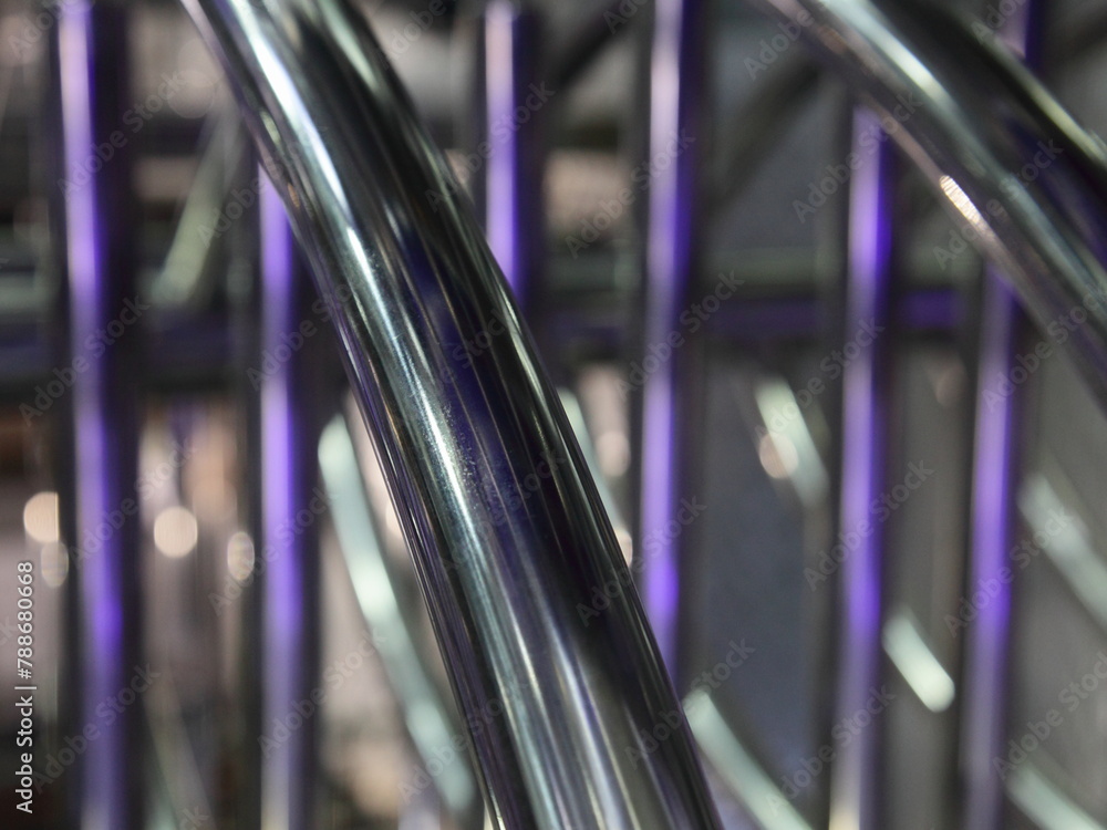 industrial abstract metal background with diagonal and vertical chrome pipe lines with purple back light