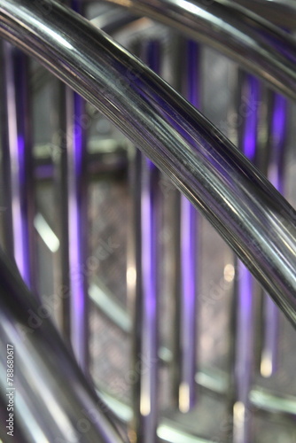 industrial abstract metal background with diagonal and blurred vertical chrome pipe lines