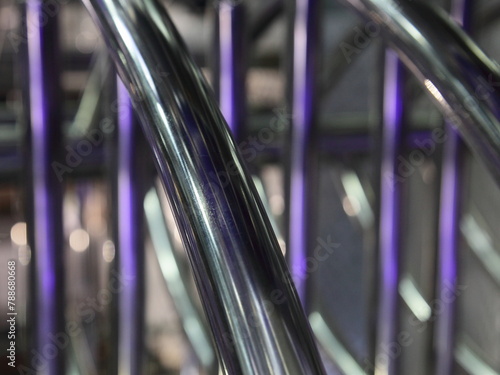 Obraz na płótnie industrial abstract metal background with diagonal and vertical chrome pipe lines with purple back light w salonie