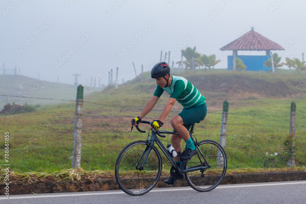 Fototapeta premium lifestyle concept. cyclist on the road training. general plan. side view