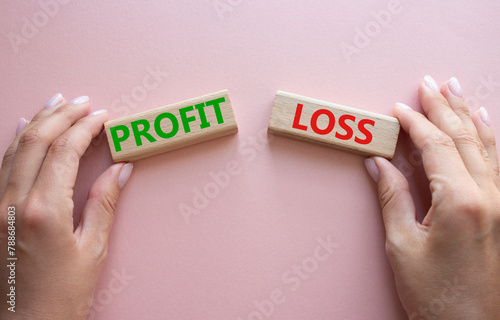 Profit or Loss symbol. Concept word Profit or Loss on wooden blocks. Businessman hand. Beautiful pink background. Business and Profit or Loss concept. Copy space