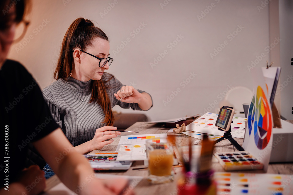 Fototapeta premium An artist meticulously studies a color chart, her gesture and intense gaze reflecting the precision required in planning the color scheme for her artwork