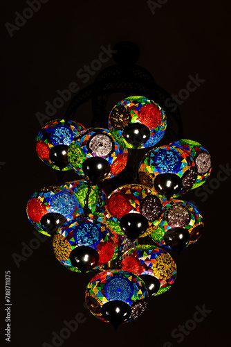 Traditional vintage of turkish lamps hanging on the ceiling at night. Exquisite colorful mosaic glass lamps, closeup, Turkey