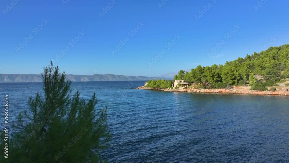 AERIAL: An abandoned house and chapel on rocky coast overlook the Adriatic sea. Scenic drone shot of the lush Mediterranean vegetation surrounding two decaying buildings on a remote beach in Hvar. AERIAL: An abandoned house and chapel on rocky coast overlook the Adriatic sea. Scenic drone shot of the lush Mediterranean vegetation surrounding two decaying buildings on a remote beach in Hvar.