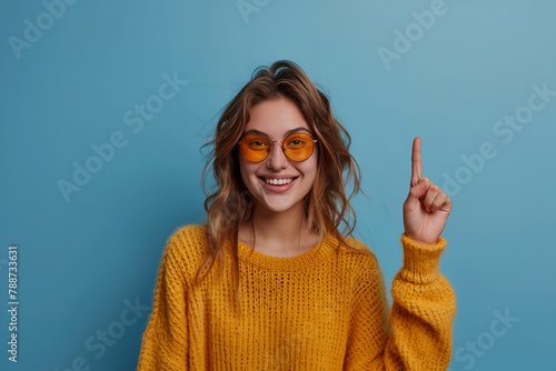 Portrait of young funny woman brown curls direct finger empty space shocked see secrets isolated on blue color background photo