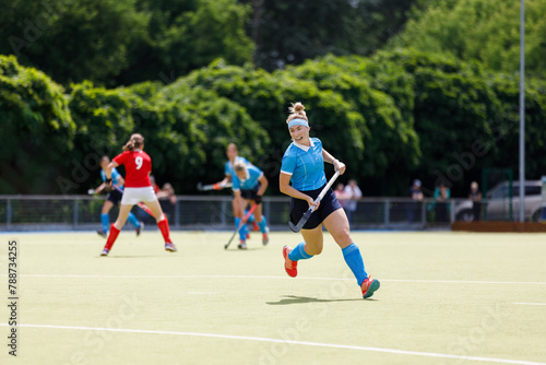 Young field hockey player run on the pitch in attack. © skumer