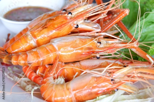  A dish full of grilled prawns with a spicy sauce on a food table