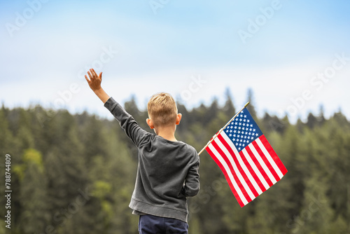 Happy boy holding American USA flag outdoors, people patriotism, 4th of July concept.  © kieferpix