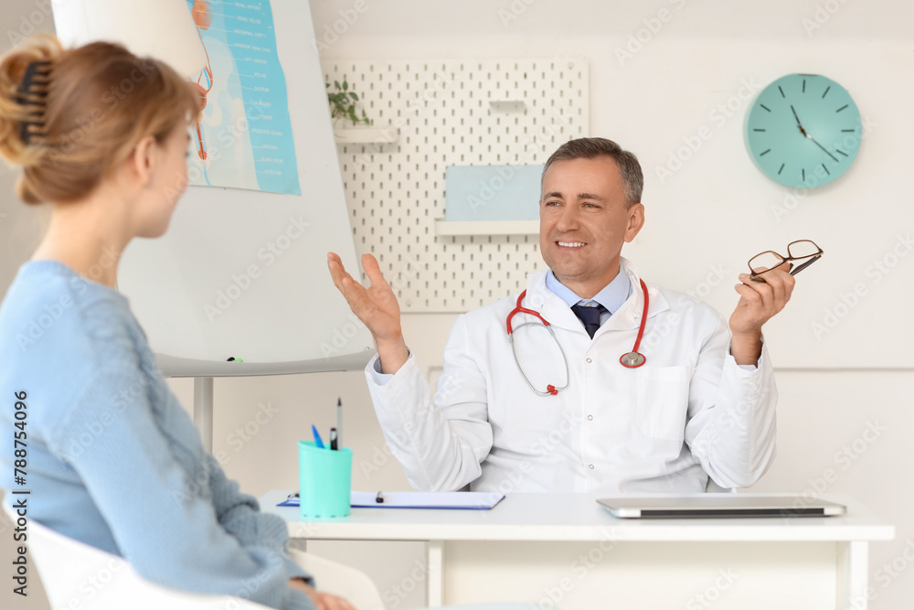 Mature doctor working with patient at desk in medical office Mature doctor working with patient at desk in medical office
