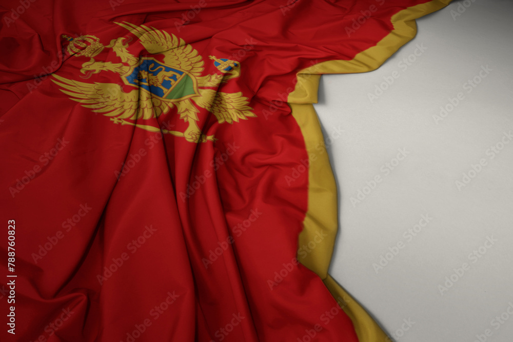 waving national flag of montenegro on a gray background.