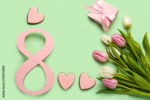 Figure 8 made of paper with tulip flowers, gift box and cookies on green background. International Women's Day celebration © Pixel-Shot