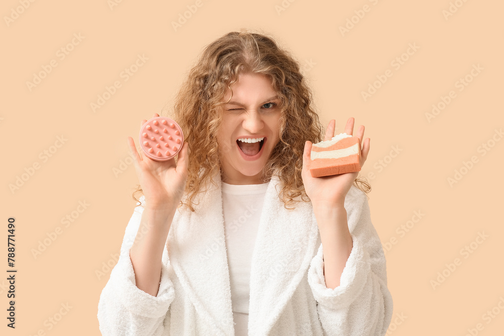 Beautiful young woman with hair scalp massager and shampoo bar on beige background Beautiful young woman with hair scalp massager and shampoo bar on beige background