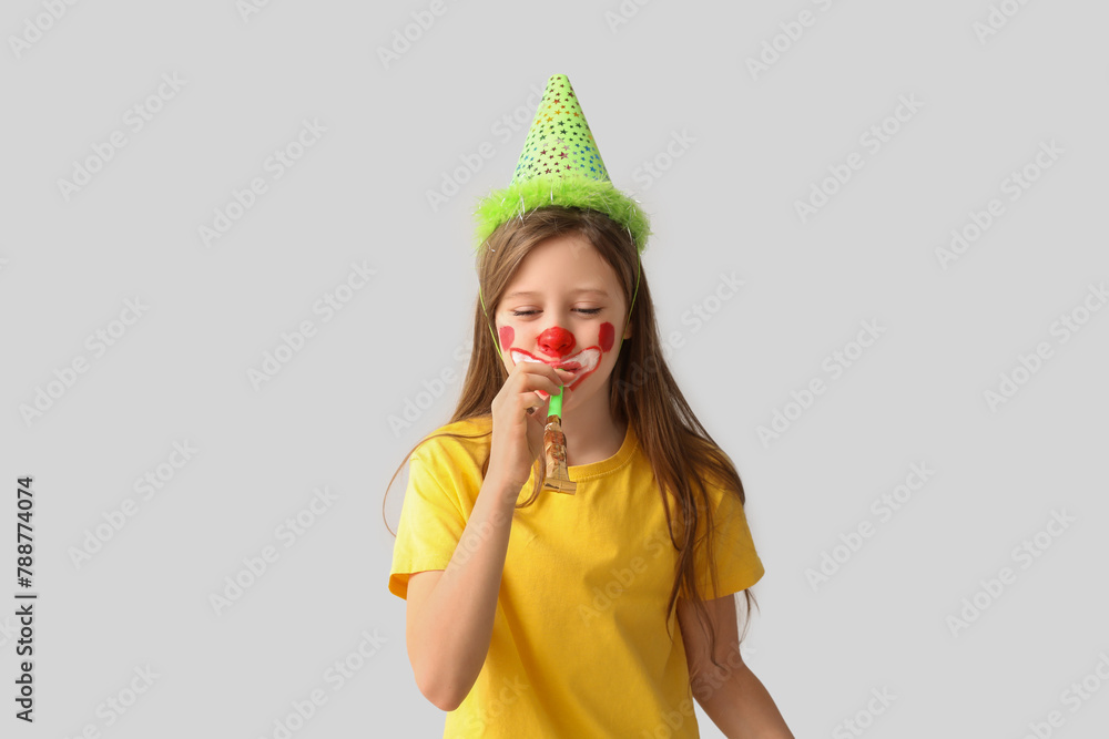 Funny girl with clown makeup, party hat and whistle on white background. April Fool's Day celebration Funny girl with clown makeup, party hat and whistle on white background. April Fool's Day celebration