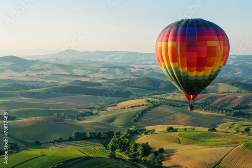 Hot Air Balloon Flying in the Sky Over Green Fields in the Morning