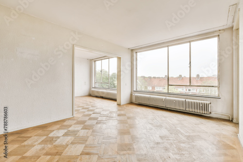Spacious empty room with large windows and parquet floor