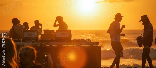silhouettes at sunset of beach party with dj
