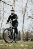 Focused man on bicycle in park with headphones, active lifestyle concept.