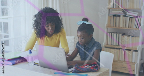 African American mother and daughter are looking at laptop in a home office