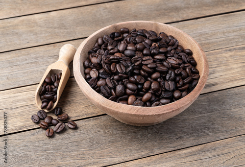Coffee beans on a bowl over wooden table