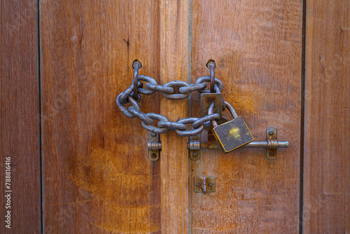 Doha, Qatar Close up view of a vintage lock with chain on a wooden door