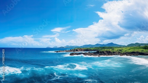Wallpaper Mural Beautiful seascape with a rocky coast and a green headland in the distance. The water is a deep blue and the sky is azure with some clouds. Torontodigital.ca