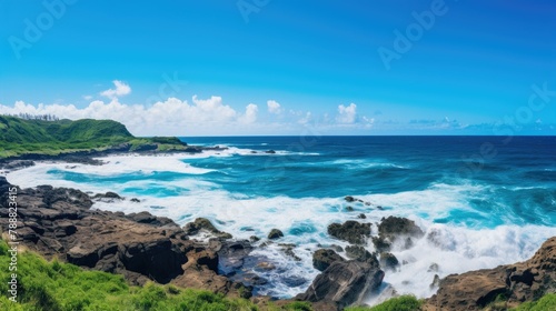 Beautiful seascape with large waves crashing on rocky coast. Blue ocean  white clouds  and green vegetation on the shore.