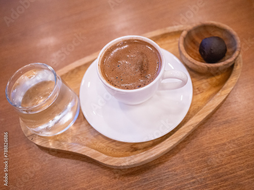 a cup of trukish coffee and glass of water on the table of cafe in istanbul