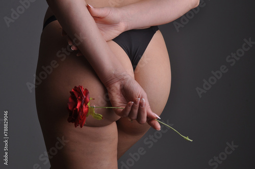 beldade sexy segurando rosa perto do bumbum  photo