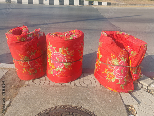 BANGKOK, THAILAND : April 18, 2024 - Red mattress with beautiful flower pattern on the side of the road waiting for the garbage truck to take it away at Thailand.