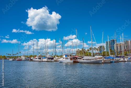 Kewalo basin marina in Honolulu Hawaii white clouds blue sky pleasure sailboats skyscrapers