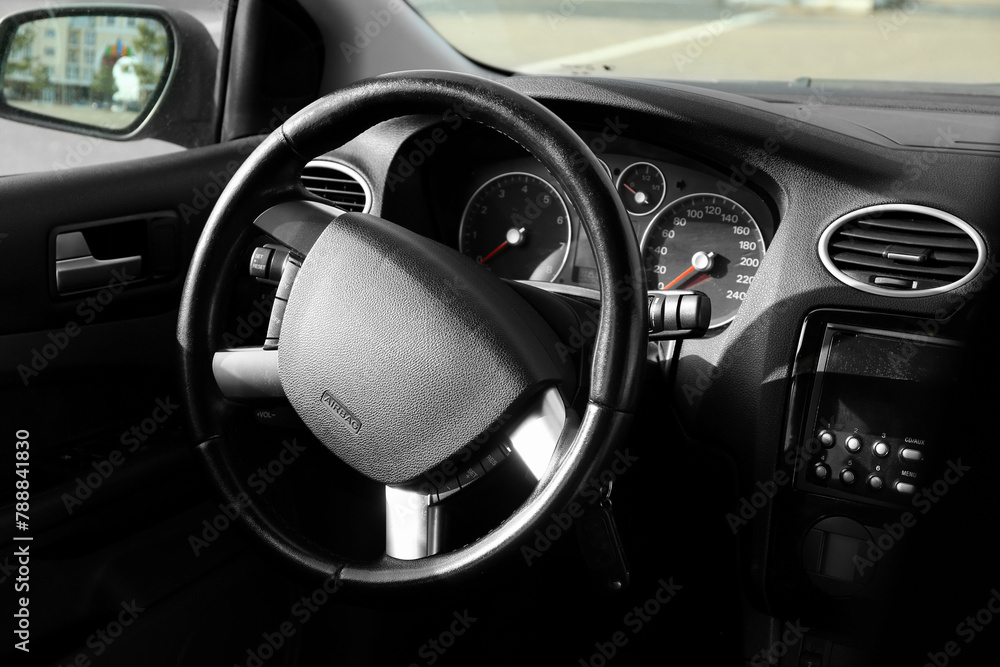 Fototapeta premium Black steering wheel and dashboard in car